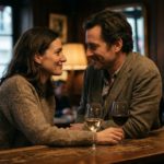 Un couple échange un regard complice et chargé de tension lors d'un verre en soirée